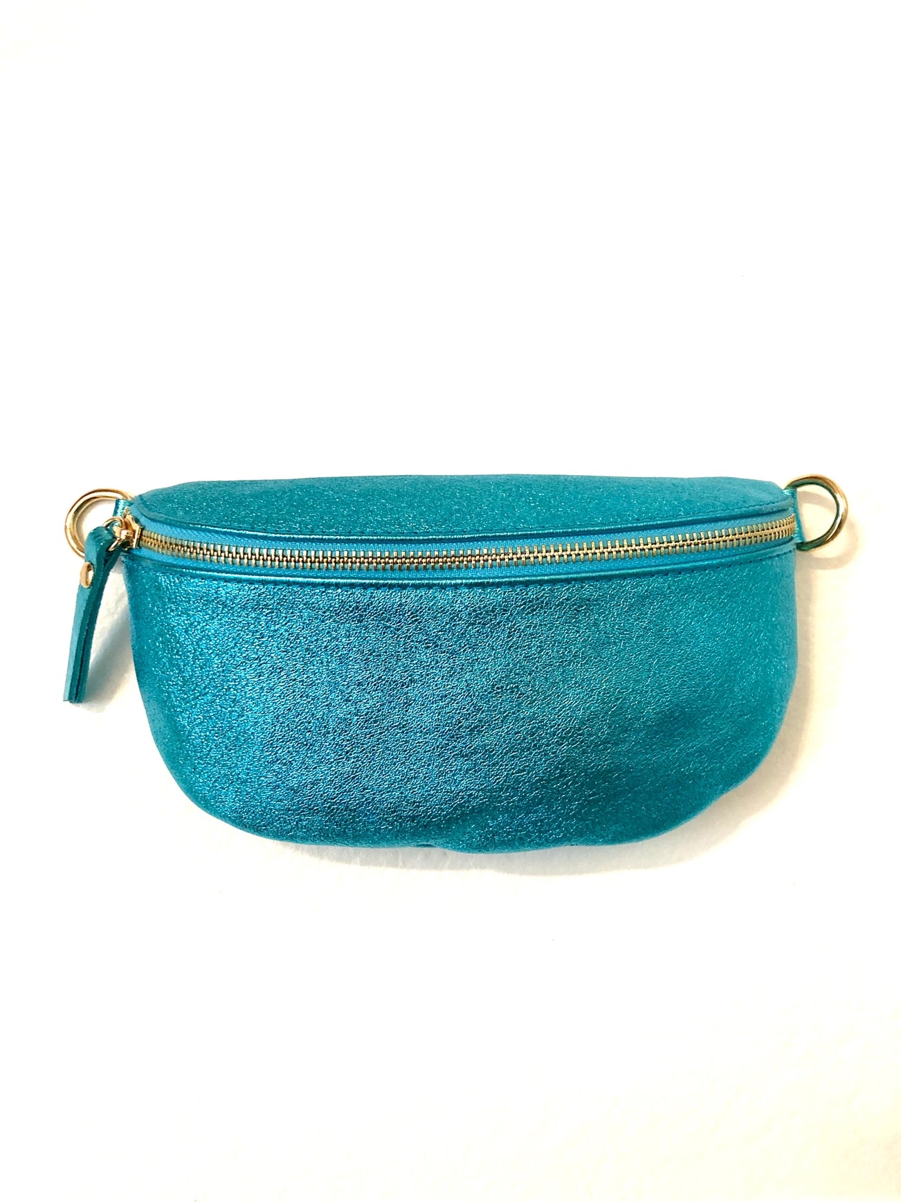 The Cassette Barcelona Metallic Leather Fanny Pack Crossbody Bag in turquoise features a glittery finish, zip closure, and gold rings on each side. Photographed against a white background.