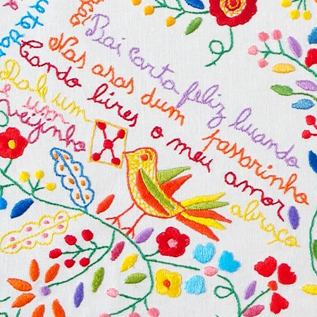 The Lovers’ Handkerchiefs Notebook by Terra Lusa features vibrant embroidery-inspired designs of birds, flowers, and cursive Portuguese phrases, evoking traditional Minho style with motifs like “Para carta feliz quando” and “Dale um beijo.”.