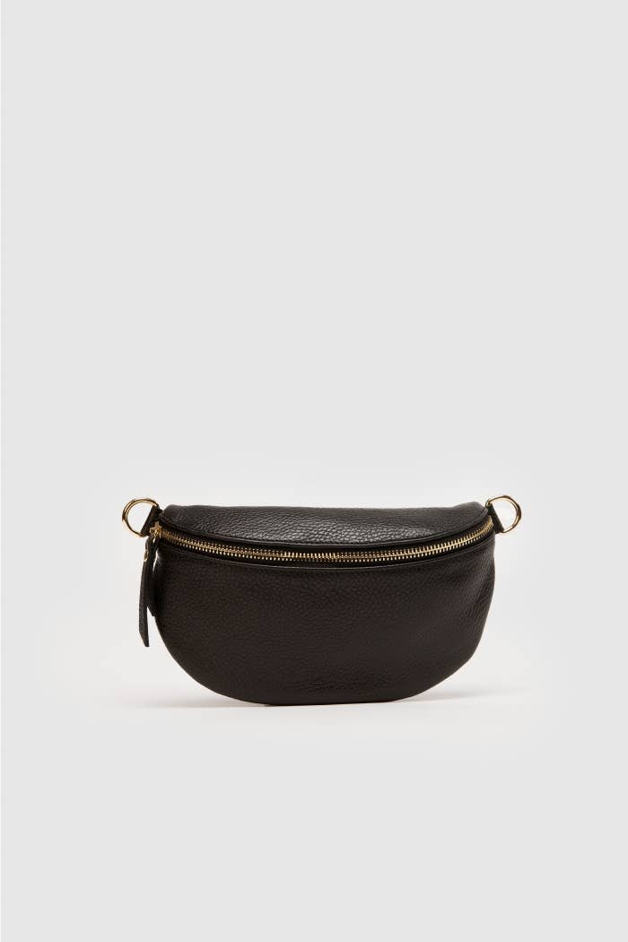 The Cassette Barcelona Leather Fanny Pack Crossbody Bag, in small black premium leather with a gold zipper and two gold side rings, is displayed on a plain light gray background.