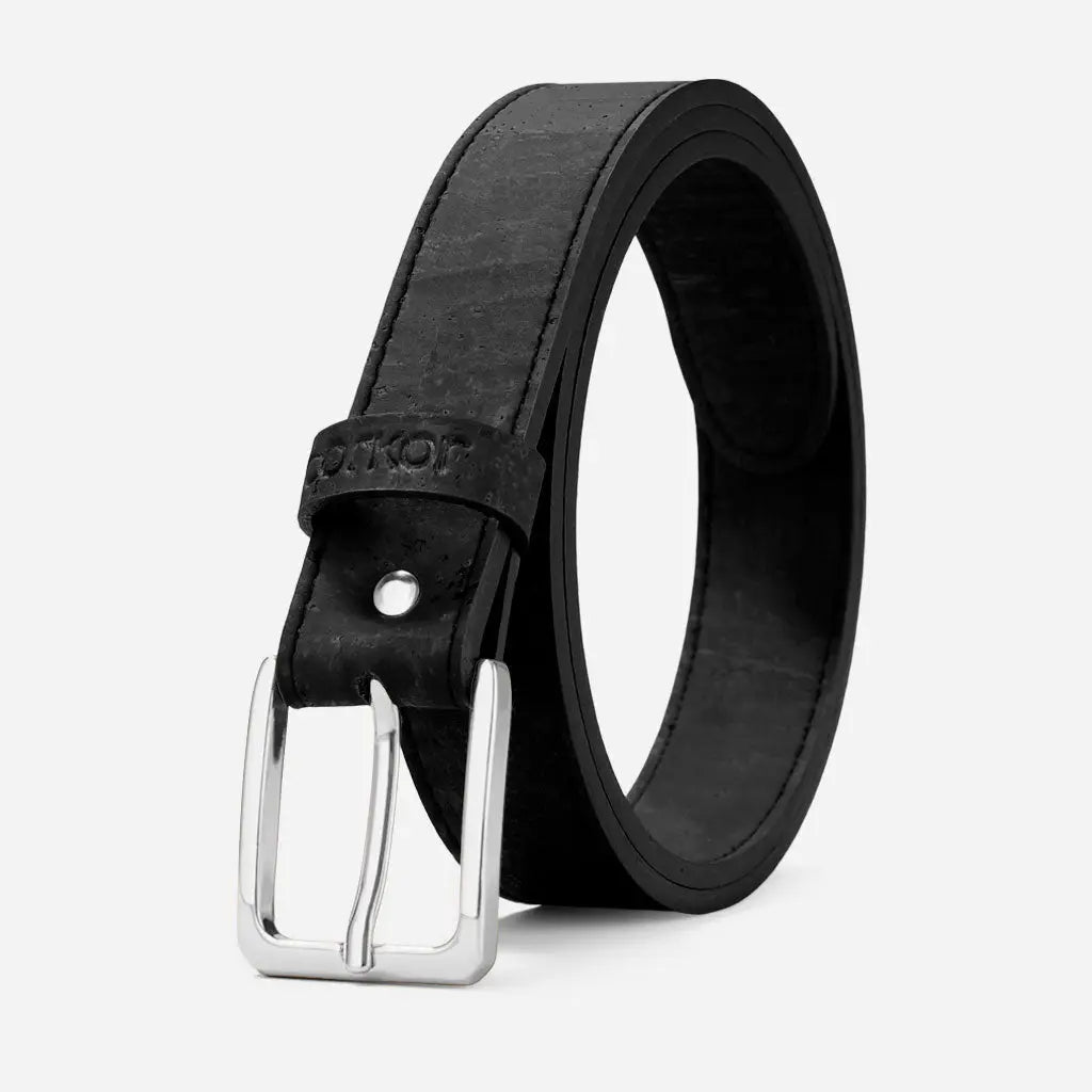 The Corkor Womens Cork Belt – 30mm with Silver Buckle is a black vegan accessory featuring textured cork material and a silver rectangular buckle, shown coiled upright against a plain light background.
