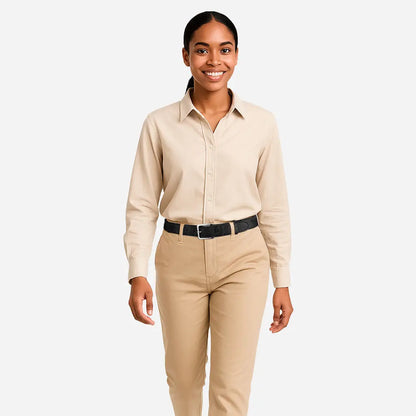 A woman smiles while standing against a white background, wearing a beige button-up shirt tucked into matching pants and accessorized with the Corkor Womens Cork Belt – 30mm with Silver Buckle.