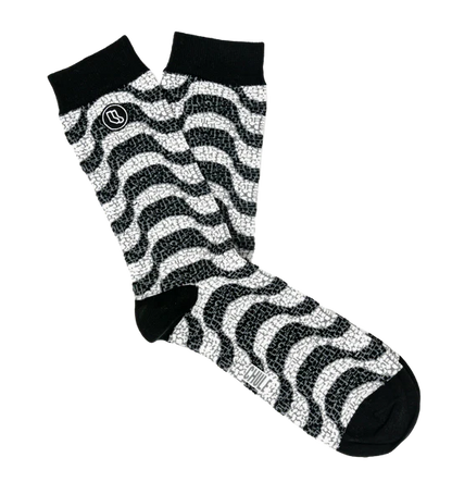 The Souvenir sock box by Iberica - Pretty things from Portugal includes black and white crew socks with a wavy zigzag pattern, solid black toes, heels, cuffs, and a small circular logo near the top of one sock.