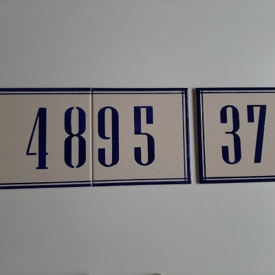 Two rectangular Handpainted Ceramic Door Numbers by TilePassion, featuring large blue numbers and borders on white tiles, are mounted on a wall—showcasing custom Portuguese tiles ideal for personalized address plaques.