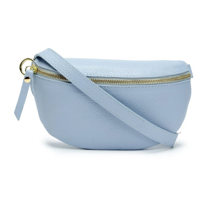 The Cassette Barcelona Leather Fanny Pack Crossbody Bag features premium light blue leather, a gold zipper, and matching strap, shown against a white background.