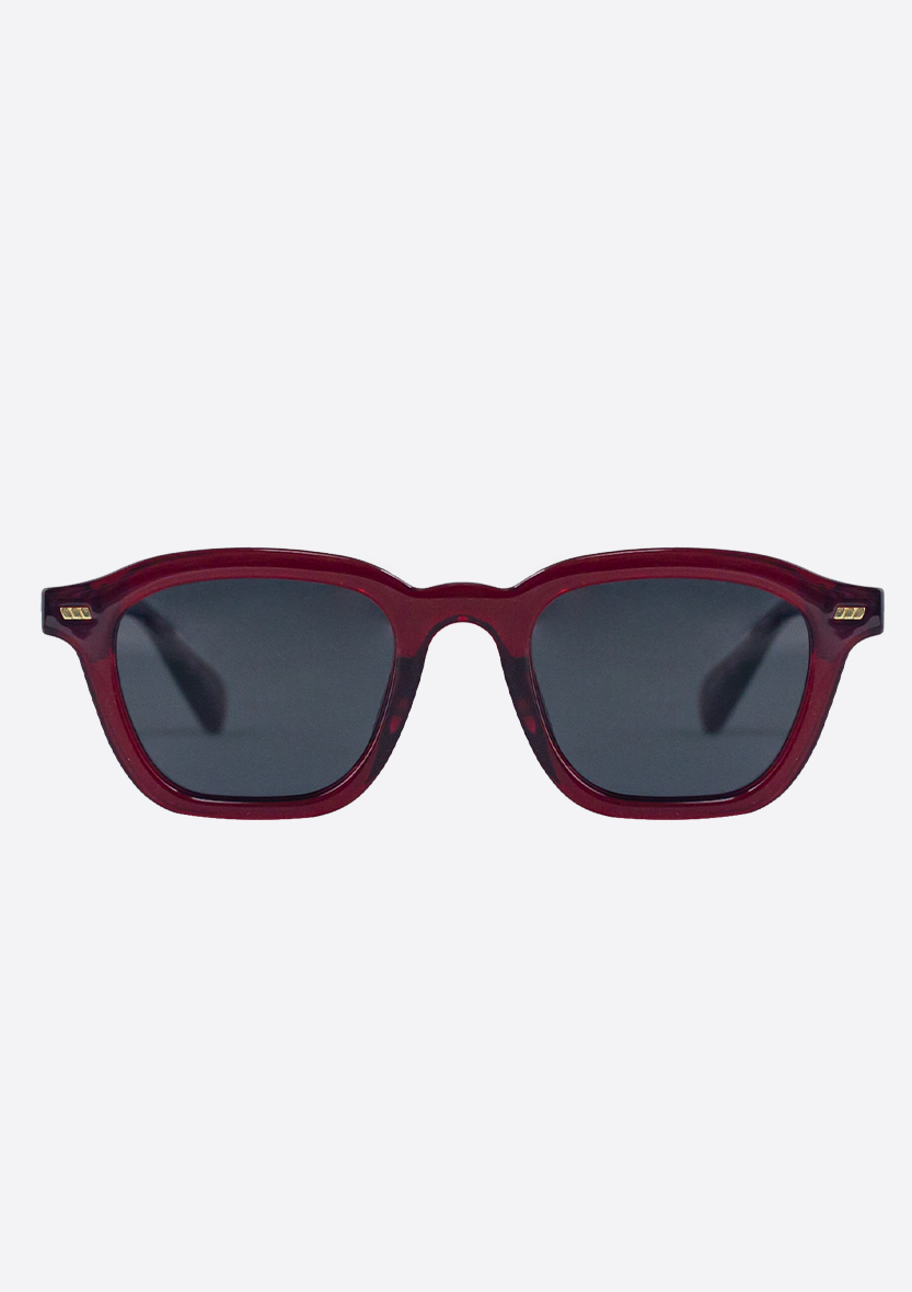 Oceanides Neda Crystal Red Sunglasses feature square, dark lenses, subtle gold temple accents, and a recycled plastic frame, shown against a plain white background.