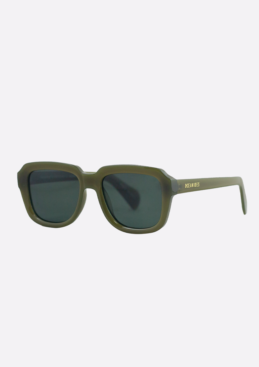 Olive green rectangular Petrea Low Verde sunglasses by Oceanides, with dark polarized lenses, thick frames, and the brand name in gold on the left temple, displayed on a plain light background.