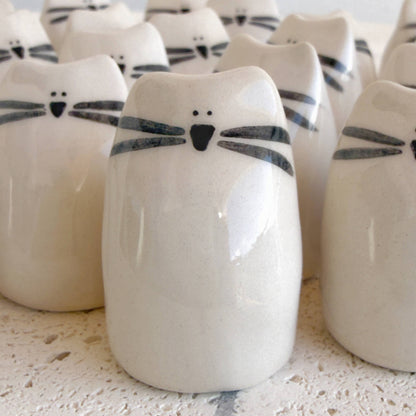 Picuru ceramicas' Kitten Amulet of Cuddles features white handmade ceramic cat figurines with simple black details, making a charming friendship or comfort gift.