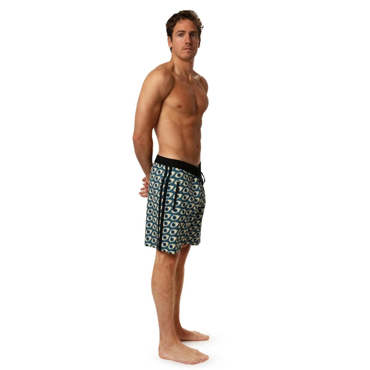 Man wearing Futah Daintree Blue boardshorts with geometric eye pattern