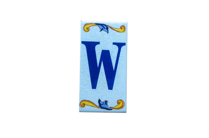 Lisa Croquets Letters – Ceramic House Letter Tile featuring a rectangular design with a blue letter W, accented by yellow and blue scrollwork patterns at the top and bottom.