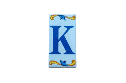 Lisa Croquets Letters – Ceramic House Letter Tile featuring a rectangular blue letter K decorated with blue and yellow scrollwork at the top and bottom.