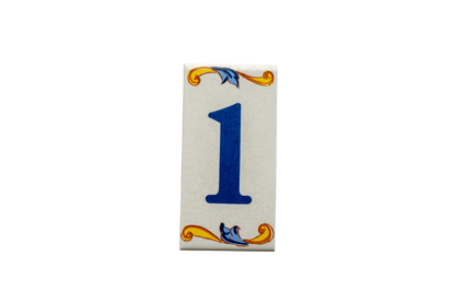 Lisa Croquets Numbers – Ceramic House Number Tiles, handcrafted in Spain, feature the number one in blue on a rectangular tile with yellow and blue scrollwork at the top and bottom.