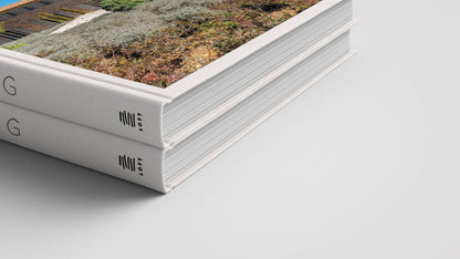 Two hardcover coffee table books with white spines are stacked on a white surface. The top book, "Mallorca Living" by Loft Publications, displays a landscape photo and minimalist black text inspired by Mallorca architecture.
