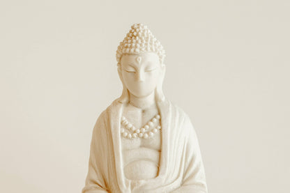 The Manulena Decorative & Aromatic Buddha Piece (White) features closed eyes, curly hair, and a beaded necklace—offering serene decor that doubles as a scented Buddha with Exotic Orchid Fragrance.
