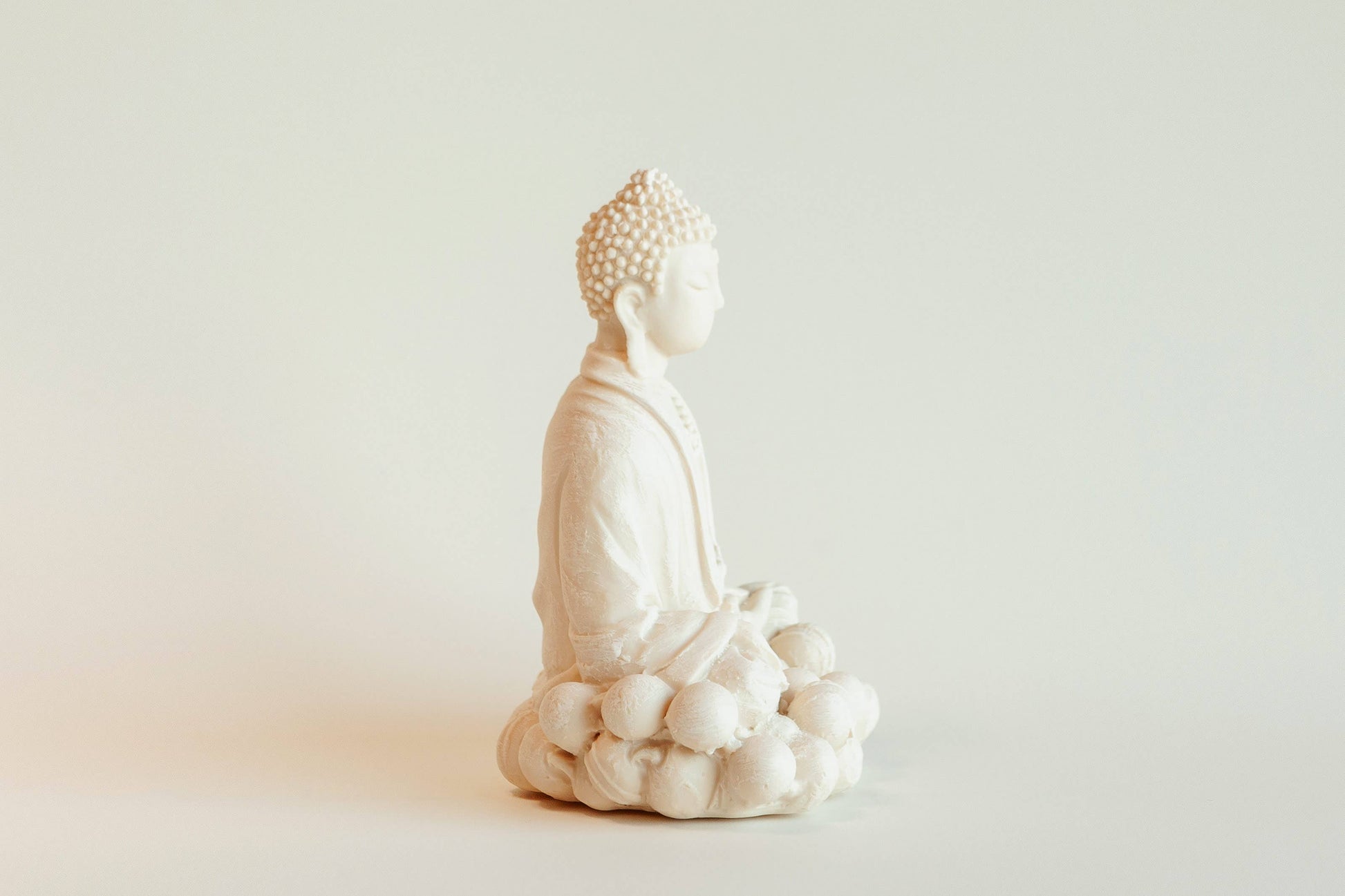 The Manulena Decorative & Aromatic Buddha Piece (White) features a serene Buddha in meditation on a lotus base, facing left. Its calming presence and minimalist design make it an ideal accent for tranquil spaces.