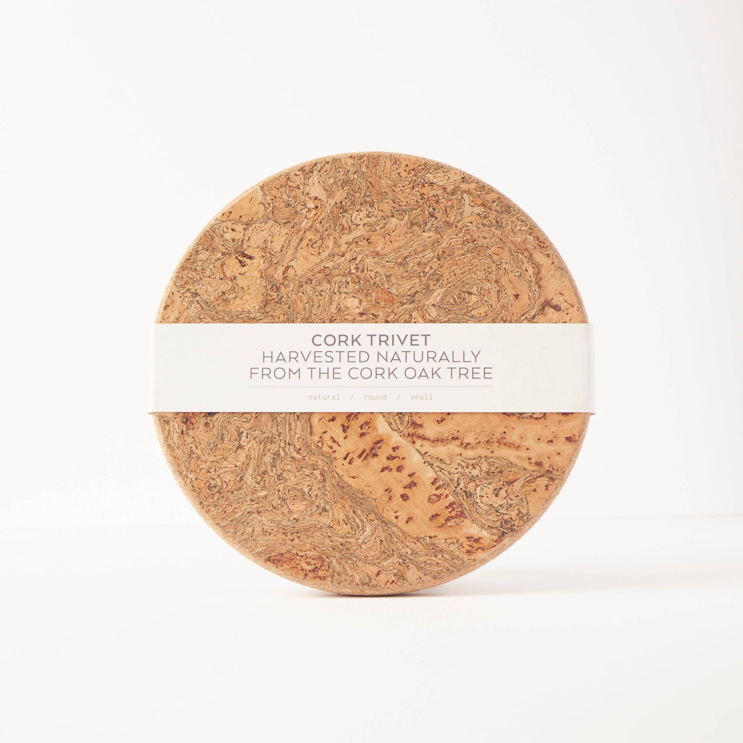 The LIGA Natural Cork Trivet - Round Small, labeled "Eco Sustainable Homeware" and made from cork oak, features a marbled finish and comes wrapped in a white band, offering an eco-friendly choice against a plain white background.