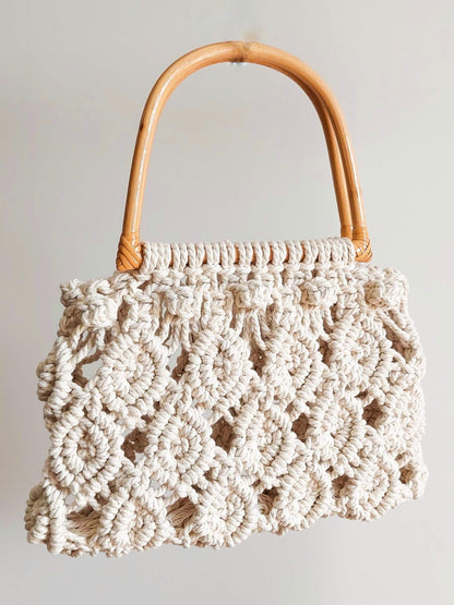 a macrame handbag in white with wooden handle