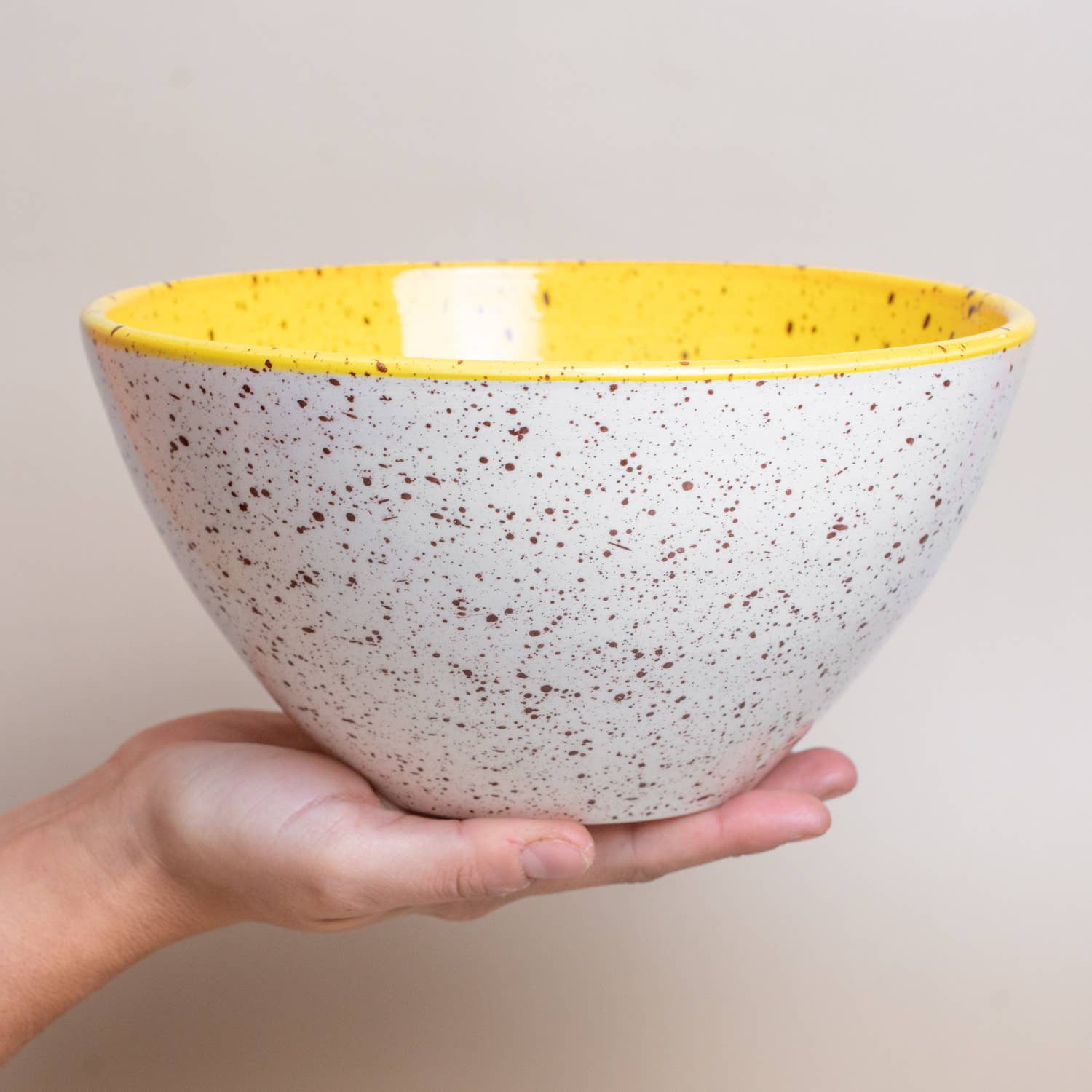 Yellow bowl held in the palm of a hand