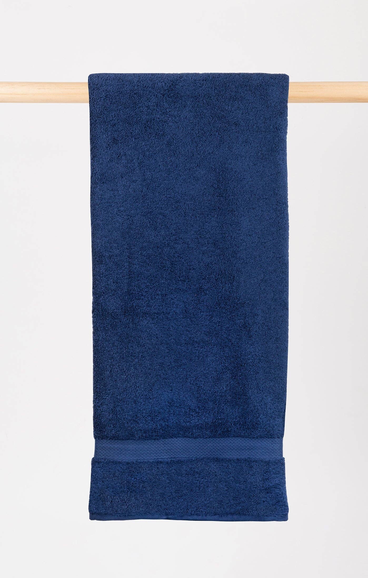 cobalt blue almonda towel hanging on a wooden rail