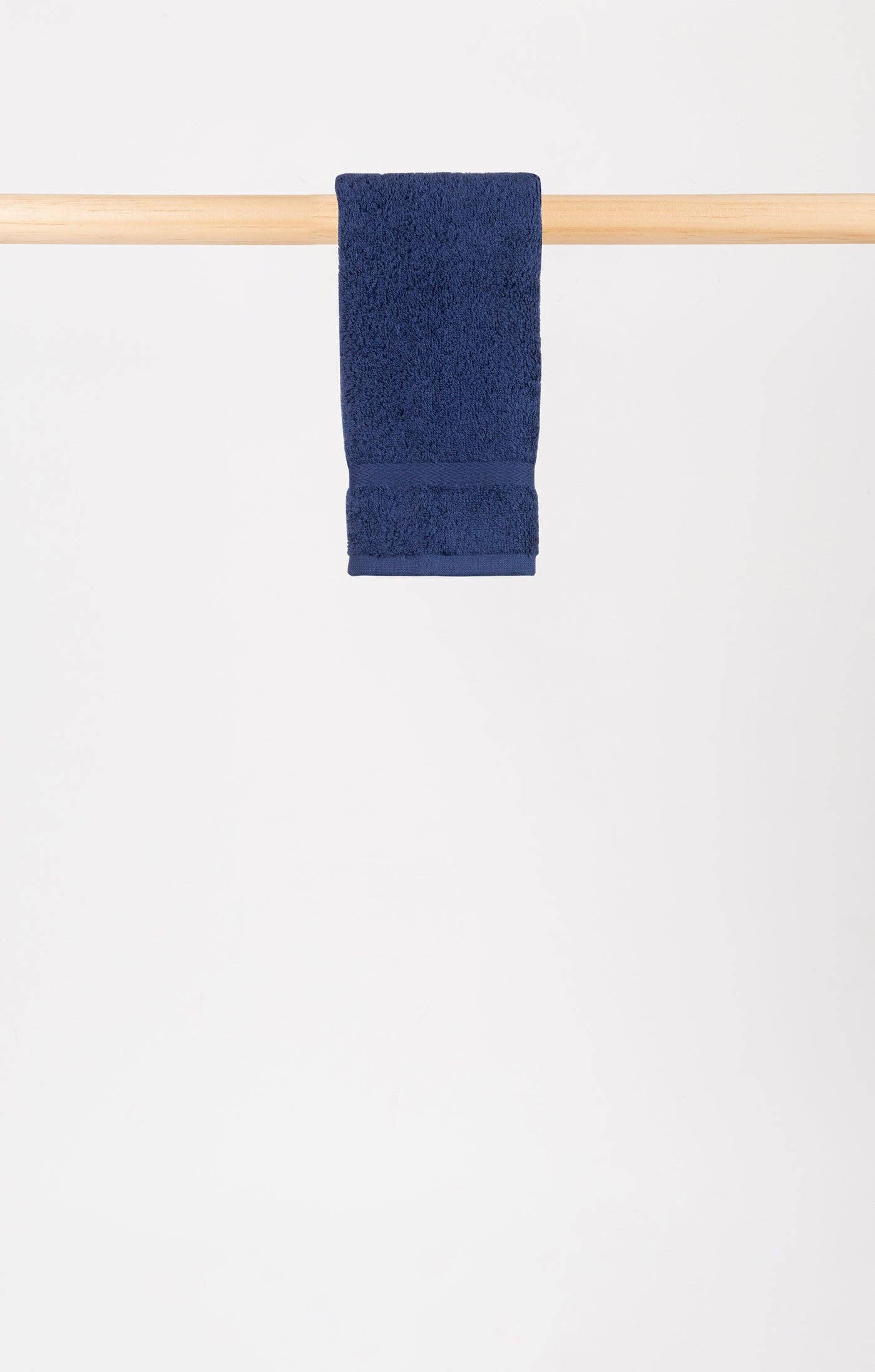 cobalt blue almonda hand towel hanging on a wooden rail