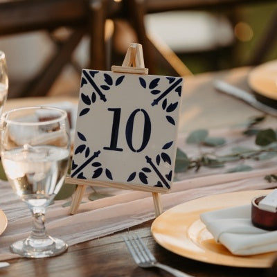 hand painted tile with a number 10 on a wedding table